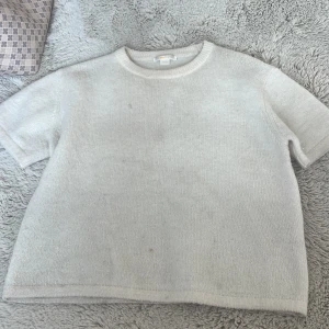 Ljus stickad tröja från Gina Tricot - En enkel och stilren ljus stickad tröja från Gina Tricot. Tröjan har korta ärmar, rund halsringning och är gjord i ett mjukt material som passar perfekt till lager-på-lager. Perfekt för dig som gillar en clean och avslappnad look.