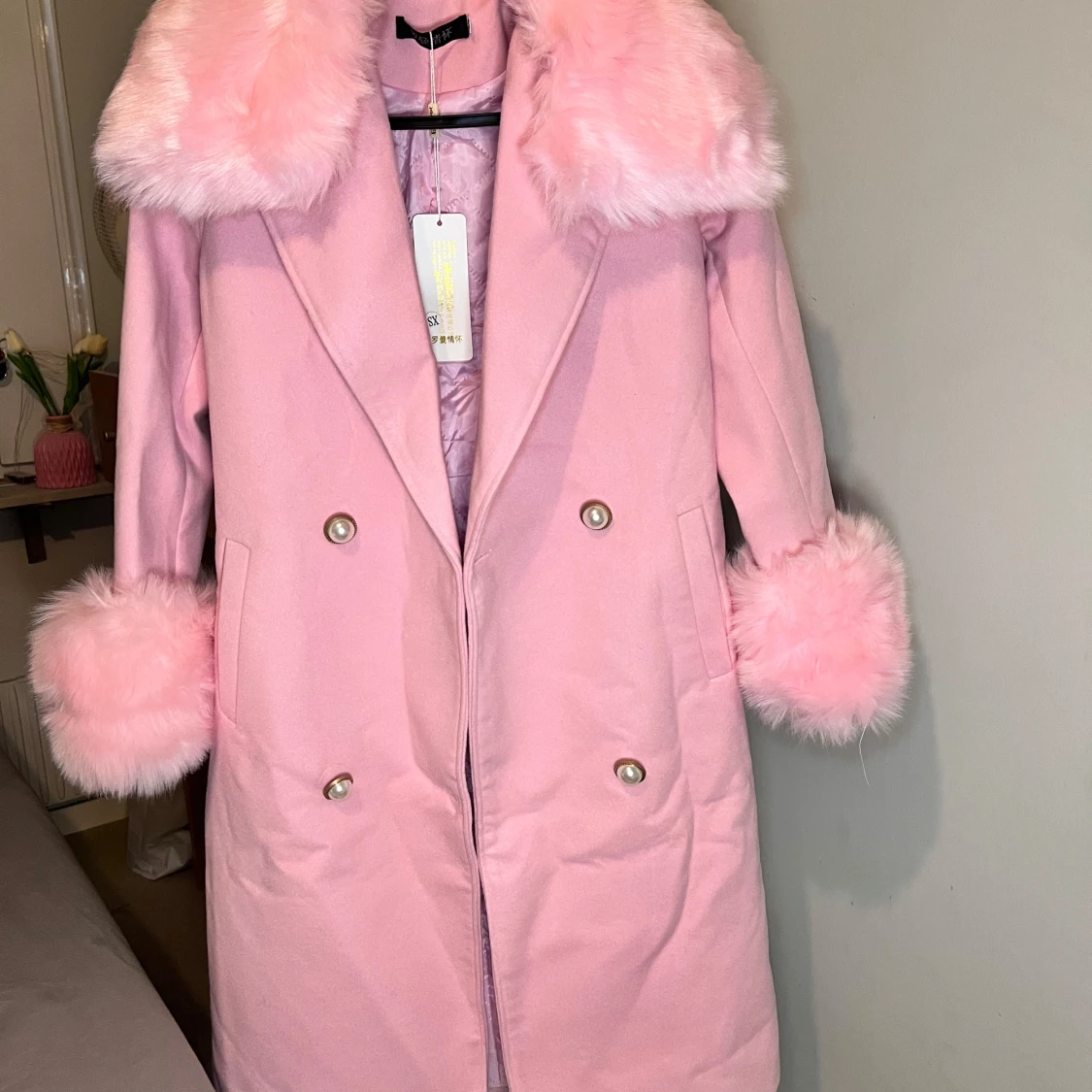 Rosa kappa med fuskpäls och pärlknappar med bälte 