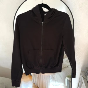Svart zip hoodie - En svart hoodie från H&M Divided i storlek XS. Tröjan har dragkedja framtill, två fickor och huva. Kedjan har tappat lite färg!