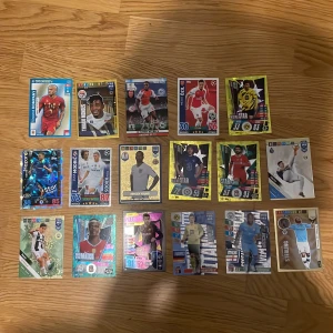 Samling av fotbollskort - UEFA, FIFA 365 & Champions League - Cool samling av fotbollskort med stjärnor som Hazard, Modric, Sterling och fler! Perfekt för dig som älskar fotboll, samlar på sportkort eller vill byta med vänner. Flera glänsande och specialkort ingår. Gör din samling komplett och hitta dina favoriter bland världens bästa spelare!