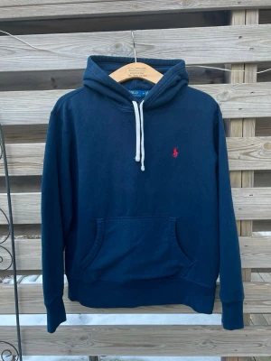 Marinblå Ralph Lauren Hoodie  - Snygg Marinblå Ralph Lauren Hoodie. Storlek M, passar dock som en lite kortare S eller större XS. Fint skick, hör gärna av er vid funderingar🙌 perfekt för vinterkylan☃️