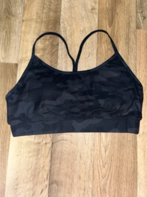 Sport BH kamoflage - En sport BH från Intersport i svart kamoflage. Bra passform som sitter bra under hela träningspasset. Använd ett flertal gånger