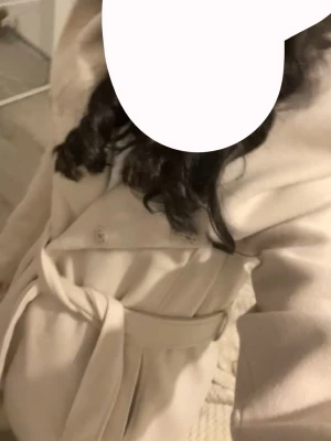 Beige kappa från Amisu med bälte - Snygg beige kappa från Amisu Classic Collection i storlek 40. Jackan har ett brett krage, knappar framtill och ett matchande bälte i midjan. Materialet är mjukt och känns lyxigt, perfekt för dig som vill ha en clean och stilren look. Kappan är i gott skick men något noppig