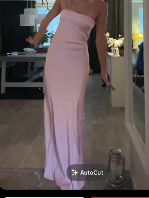 Ljusrosa satin långklänning med öppen rygg - Elegant ljusrosa satin långklänning med axelbandslös design och snygg öppen rygg. Storlek S! 🩷💗💖 Jag är 173cm till referens och det är jag på alla bilderna:) Endast testad , balklänning 