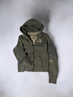 Sällsynt hollister tröja med knappar - Hej, säljer denna fina tröja från hollister perfekt nu till vintern och med otroligt fina broderier.  || märke: hollister   || skick: väl bevarad   || speciellt: den har otroligt fina knappar och fina broderier vilket gör den väldigt unika och det finns inte många som har en sån här tröja   || övrigt: pris går att diskutera så hör av er vid funderingar! Står L men passar som ungefär en S/M (se mått)  Få tal skavanker men det är inget som synsättet 