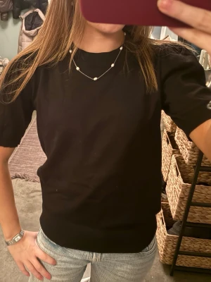 Svart t-shirt från Saint Tropez XS - Säljer en svart t-shirt från Saint Tropez i storlek XS. Modellen har korta ärmar och en rundad hals med ribbad kant. T-shirten är enkel och stilren, perfekt till jeans eller kjol. Materialet känns mjukt och bekvämt mot huden.