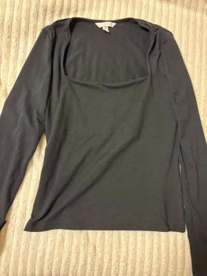Svart långärmad topp från H&M - En svart långärmad topp från H&M med en snygg, något fyrkantig urringning. 