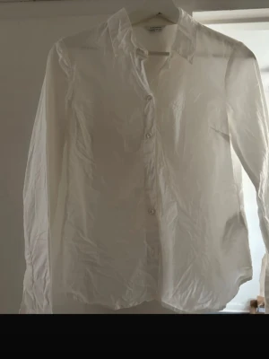Vit skjorta från Bubbleroom - Säljer en klassisk vit skjorta från Bubbleroom i storlek 34. Skjortan har lång ärm, krage och knappar framtill. Perfekt för dig som gillar en clean och stilren look. Materialet känns lätt och bekvämt mot huden.