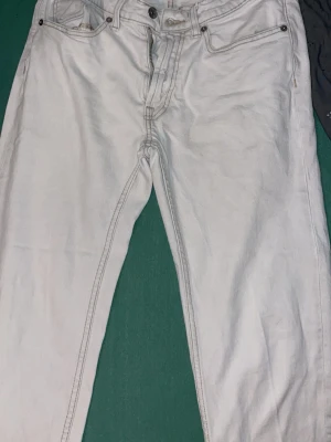 Vita jeansbyxor från Dressmann - Snygga vita jeansbyxor från Dressmann med klassisk femficksdesign och kontrastsömmar. Modellen är regular fit och har knapp och dragkedja i gylfen. Perfekta för dig som gillar stilrena och ljusa jeans med rak passform.