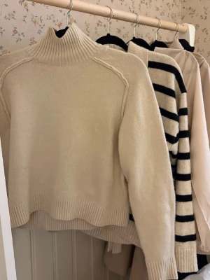 Beige polotröja stickad - Säljer en beige stickad polotröja med ribbad hög krage och muddar. Tröjan är från HM och sitter väldigt fint på, säljer då jag har en nästan likadan💞 Bilden är lånad!!! Skriv vid frågor🩷🩷⚠️Använd cirka 3 gånger⚠️