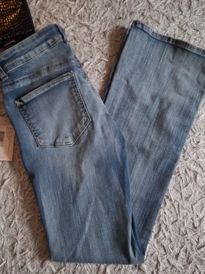 Blå low waist bootcut jeans - Low waist jeans från Nelly, aldrig använda med prislappen på, tyvärr var det lite förstora på mig. 