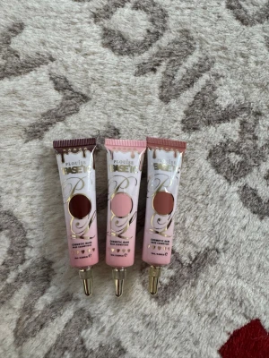 P.Louise Base ögonskuggsprimer 3-pack - Tre tuber P.Louise Base ögonskuggsprimer i olika nyanser: en mörkbrun, en ljusrosa och en varm nude. Tuben är rosa med gulddetaljer och har en praktisk spetsapplikator i guld. Perfekt för att få ögonskuggan att sitta hela dagen och ge extra pigment.