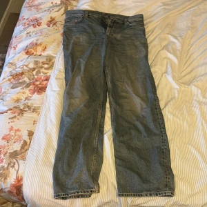 Weekday Galaxy Loose Straight Jeans 31/32 - Säljer ett par Weekday Galaxy Loose Straight Jeans i klassisk blå tvätt. Jeansen har en loose fit med raka ben och normal midja. Tillverkade i bomull och perfekta för en avslappnad och trendig look. Passar dig som gillar bredare siluett och streetstyle.