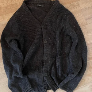 Svart stickad kofta - Svårt stickad kofta från emilio. Man kan båda ha en t shirt under eller en hoodie. Väldigt snygg nu till vintern. Bara höra av sig om man har någon fundering.