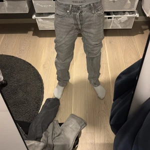 Gråa Jack&Jones jeans - Tjenare! Säljer nu ett par gråa byxor då dem ej e min stil. | Modell: Loose/Chris | Färg: 🩶| Storlek: W27 L30 | Frakt: Samma dag som köpet! ( gäller ej helger ) | Defekter: byxorna har lite defekter vid benändan som syns i bild 3! Inte de versta och går att sy ifall man tycker att det är något problem! | Hör av dig vid minsta fundering, svarar så fort jag kan. 