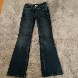 Bootcut jeans från Nelly - Säljer mina Nelly jeans i strl 34 då de inte används längre! Dom är blåa med vita detaljer på bakfickorna. Priset kan diskuteras och hör av er vid frågor!💓Tvättas innan köp!