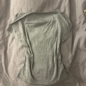 Grå öppen rygg topp från SHEIN XS - Snygg grå öppen rygg topp från SHEIN i storlek XS. Toppen är ärmlös med en öppen rygg och har en mjuk, stretchig känsla. Perfekt för dig som gillar minimalistisk stil och vill ha något enkelt men ändå trendigt. Passar dig som vill ha en slim fit look.