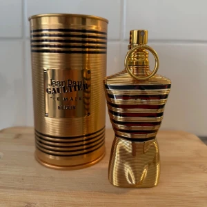 Jean Paul Gaultier Le Male Elixir Edp - Exklusiv herrparfym i en lyxig guldig flaska. Doften är Le Male Elixir, en intensiv och modern tolkning av originalet. Kommer i en matchande guldfärgad metallburk. Perfekt för dig som vill sticka ut. Ungefär 40-35ml kvar av 75ml som visas på andra fotot (kom dm för en mer detaljerad bild)! Passar fint till alla säsonger men speciellt för speciella tillfällen som studenten eller generell skolavslutning, som båda är aktuellt nu! (Nypris 1099kr). Hör gärna av er med egna bud eller frågor!
