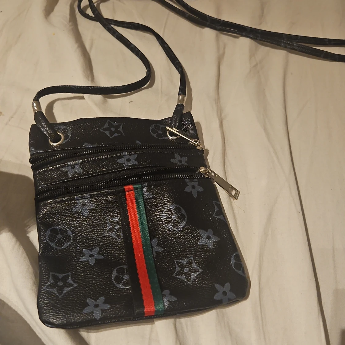 Svart axelväska med mönster och ränder