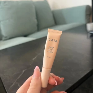 CAIA That Dewy Look Eye Gloss - Säljer en CAIA That Dewy Look Eye Gloss i en ljusbeige tub. Ger en glansig finish till ögonlocken för en fräsch och dewy look. Perfekt för att skapa en trendig wet look. Enkel att applicera med tuben och smidig att ha med i väskan.
