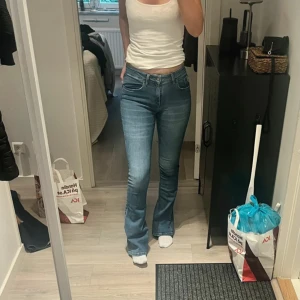 Blå bootcut jeans från Lois - Snygga blå jeans från Lois med bootcut passform och klassisk femficksdesign. Jeansen har en ljus tvätt och normalhög midja. Perfekta för dig som gillar en tidlös look med lite utsvängda ben. Märkeslapp bak på fickan.