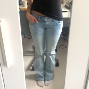 Low Waist Bootcut Jeans - Tänkte kolla intresset på dessa ljusblåa lågmidjade bootcut jeansen från G-rise i strl. S, regular length. Skitsnygga, designat med hål på vänster knä!! På bild 4 ser ni jeansens dåvarande defekter, missfärgningar från regniga/snöiga dagar. På bild 5 ser ni jeansens skick idag. Med hjälp av speciella produkter är missfärgningarna borta. Den enda defekten kvar är lite slitage vid hälarna. De säljs inte längre på hemsidan.