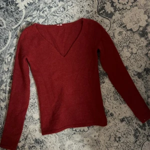 Vinröd stickad v-ringad tröja - Vinröd stickad tröja i ull med v-ringning och långa ärmar. Perfekt för hösten ❤️
