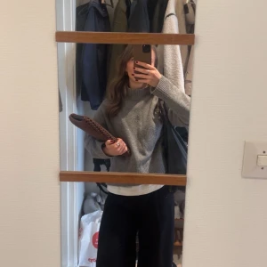 Grå stickad tröja från Uniqlo - Mysig grå stickad tröja från Uniqlo med högre ribbad krage och avslappnad passform. Tröjan har långa ärmar och breda ribbade muddar vid ärmslut och nederkant🩷