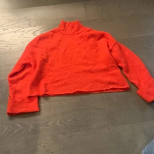 Orange polotröja med loose fit - Säljer en orange polotröja med oversized passform och långa ärmar. Tröjan har en ribbad hög krage och är stickad i ett mjukt material. Perfekt för dig som gillar en chill och trendig stil.