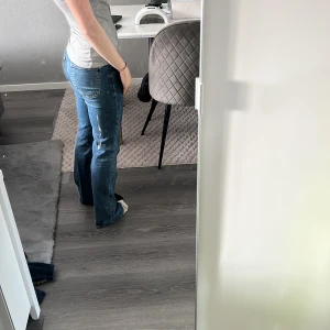 Blå bootcut jeans med fickdetaljer - Säljer ett par blå bootcut jeans med snygga fickdetaljer framtill och klassisk femficksdesign. Jeansen har låg midja 💗
