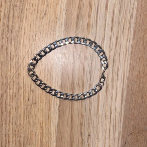 Kedjearmband i silverfärg - Stilrent armband med breda, platta länkar i silverfärg. Klassisk kedjedesign som passar perfekt för dig som gillar en enkel men cool look. Lätt att matcha med andra smycken och har ett smidigt lås.