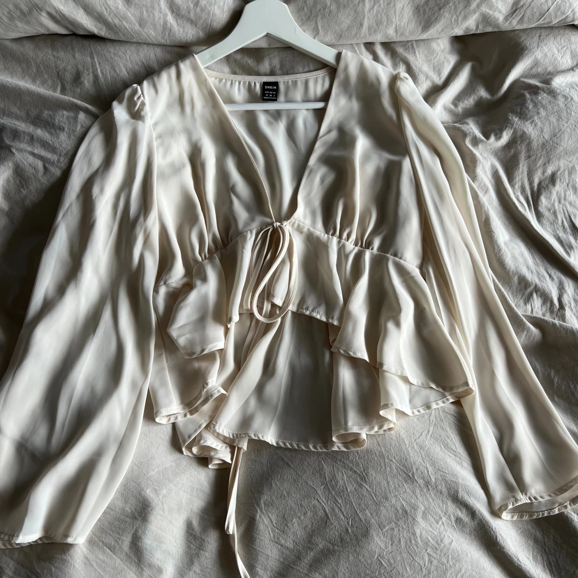 Beige blus med volang