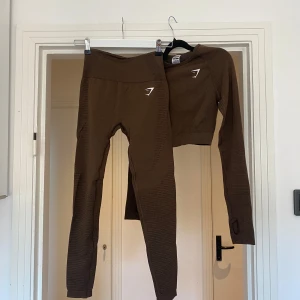 Bruna vital träningskläder från Gymshark - ”Vital leggings” och ”vital crop top” från gymshark. Båda i färg ”espresso marl”. I bra skick (använd ett fåtal gånger). Original pris för båda 998kr (549+449). Går att köpa separat (skicka dm)