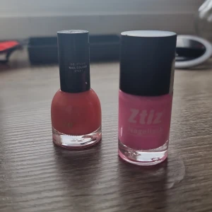 Två nagellack i rosa och korall - Säljer två snygga nagellack: ett från Ztiz i en poppig rosa nyans och ett från H&M i en fräsch korallfärg. Båda har rundade glasflaskor och svarta lock. Perfekta för att fixa naglarna med färg som sticker ut.