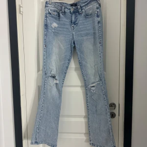 True Religion ljusblå bootcut jeans - Ljusblå jeans från True Religion med slitna detaljer och hål på knäna. Slutsålda överallt. Normala i storleken och inga skavanker eller något slitage alls 🩷🩷