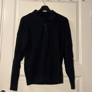 Svart pikétröja från Indicode - Svart långärmad pikétröja från Indicode med klassisk krage och tre knappar framtill. Tröjan är i mjukt material och har en stilren look som passar perfekt till jeans eller chinos. Enkel och clean design för en snygg vardagsstil. Bra skick och jätte skönt material. Sitter perfekt på mig som är 175cm lång. Hör av er vid minsta fundering eller om ni vill ha fler bilder. Kolla gärna in min profil för fler feta plagg⭐️