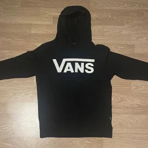 Svart Vans Hoodie - Svart hoodie från Vans i (barn storlek medium) Armlängd-52cm   Midjemått-43cm   Längd från hals och nedåt-54cm 