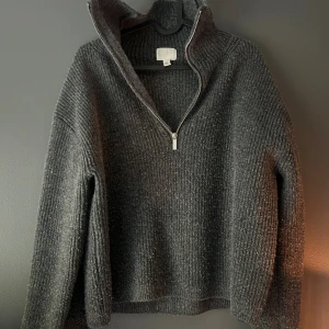 Mörkgrå stickad half zip-tröja H&M - Mysig mörkgrå stickad tröja från H&M med ribbad struktur och half zip-dragkedja i halsen. Den är lite nopprig så där av priset, men annars super bra!!🤗🤗🥰🥰