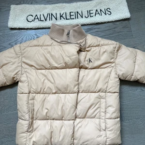 Beige pufferjacka från Calvin Klein Jeans - Snygg beige pufferjacka från Calvin Klein, använd 1 gång💕💕