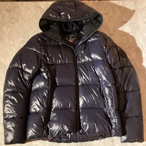 Save the duck - En snygg glansig från save the duck. Jackan har en zip som går hela vägen upp. Den är perfekt till vintern när det blir kallt och håller en varm. TAR BYTEN‼️