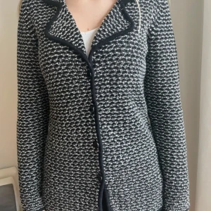 Svartvit stickad cardigan / kofta - Snygg svartvit stickad cardigan jacka med rutig känsla och markerad krage. Jackan har knappar framtill och lång ärm. Perfekt för dig som gillar en klassisk men trendig look.