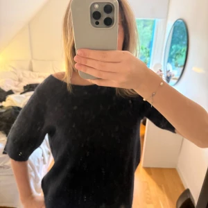 Svart stickad tröja med trekvartsärm - Mysig mörkblå stickad tröja med korta armar och bred halsringning som kan bäras offshoulder. Endast använd 1 gång