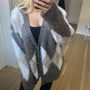 Oversized rutig kofta i beige och grått - Supermjuk och oversized kofta med stora rutiga mönster från NAKD. Koftan har v-ringning, knappar framtill och långa ärmar. Perfekt för lager-på-lager och chill vibes. Materialet är fluffigt och stickat 🥰🥰 aldrig använd därav lapp och extra knappar kvar! Såå perfekt till hösten!!😍😍 