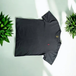 Svart t-shirt från Polo Ralph Lauren - Svart t-shirt från Polo Ralph Lauren med klassisk röd broderad logga på bröstet. T-shirten har rund hals och korta ärmar, tillverkad i mjuk bomull som känns skön mot huden. Perfekt för dig som gillar stilrena och ikoniska plagg.