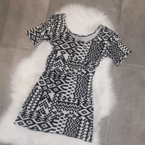 Svartvit mönstrad kortklänning, storlek XS - Kort klänning från Opposite i svartvitt grafiskt mönster. Modellen har rund halsringning och korta ärmar. Materialet är mjukt och stretchigt, perfekt för dig som gillar att sticka ut med coola prints. Se bild för längd :) 