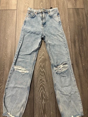 Högmidjade jeans med slitningar  - Fina högmidjade jeans från Zara med slitningar på knän och längst ner på benen 