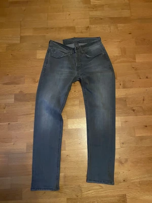 Grå jeans från Dondup - Snygga grå jeans från Dondup med klassisk femficksdesign och raka ben. Jeansen har en diskret tvättad look och är tillverkade i mjukt jeansmaterial som sitter skönt. Passar dig som gillar stilrena och moderna jeans med enkel design. Slim fit dem är 31W 32L