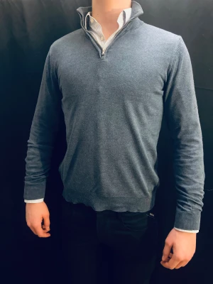 Blå half zip tröja Dressmann S - Superskön blå tröja från Dressmann i Supima bomull. Modellen har half zip i halsen, ribbade muddar och lång ärm. Perfekt för dig som gillar stilren och enkel look med lite sportig touch. Passformen är normal och materialet känns mjukt mot huden.
