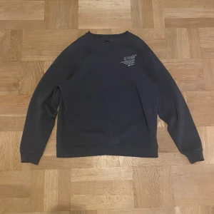 Vintage mörkgrå sweatshirt - storlek L - Cool vintage mörkgrå sweatshirt från River Island i storlek L med tryck i vitt både fram och bak. Tröjan har rund hals, långa ärmar och mjukt fleecefoder på insidan. Perfekt för dig som gillar streetwear och grafiska detaljer. Använd ca 10 gånger, tvättad efteråt.