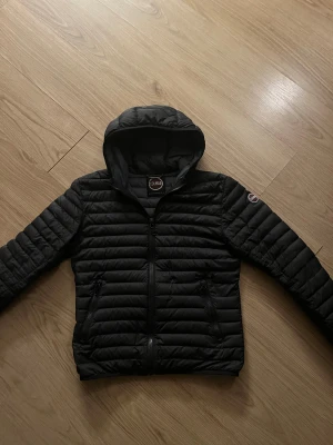 Colmar jacka - Den är i bra skick men har ett hål bakom innerfickan som inte syns alls. Den har även ett väldigt litet hål på axeln som inte syns.